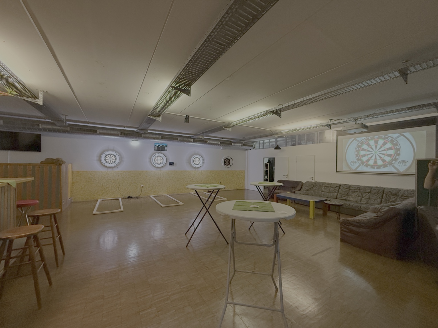 Spielstätte des DSV Kückhoven mit Dartboards, Leinwand und Aufenthaltsbereich